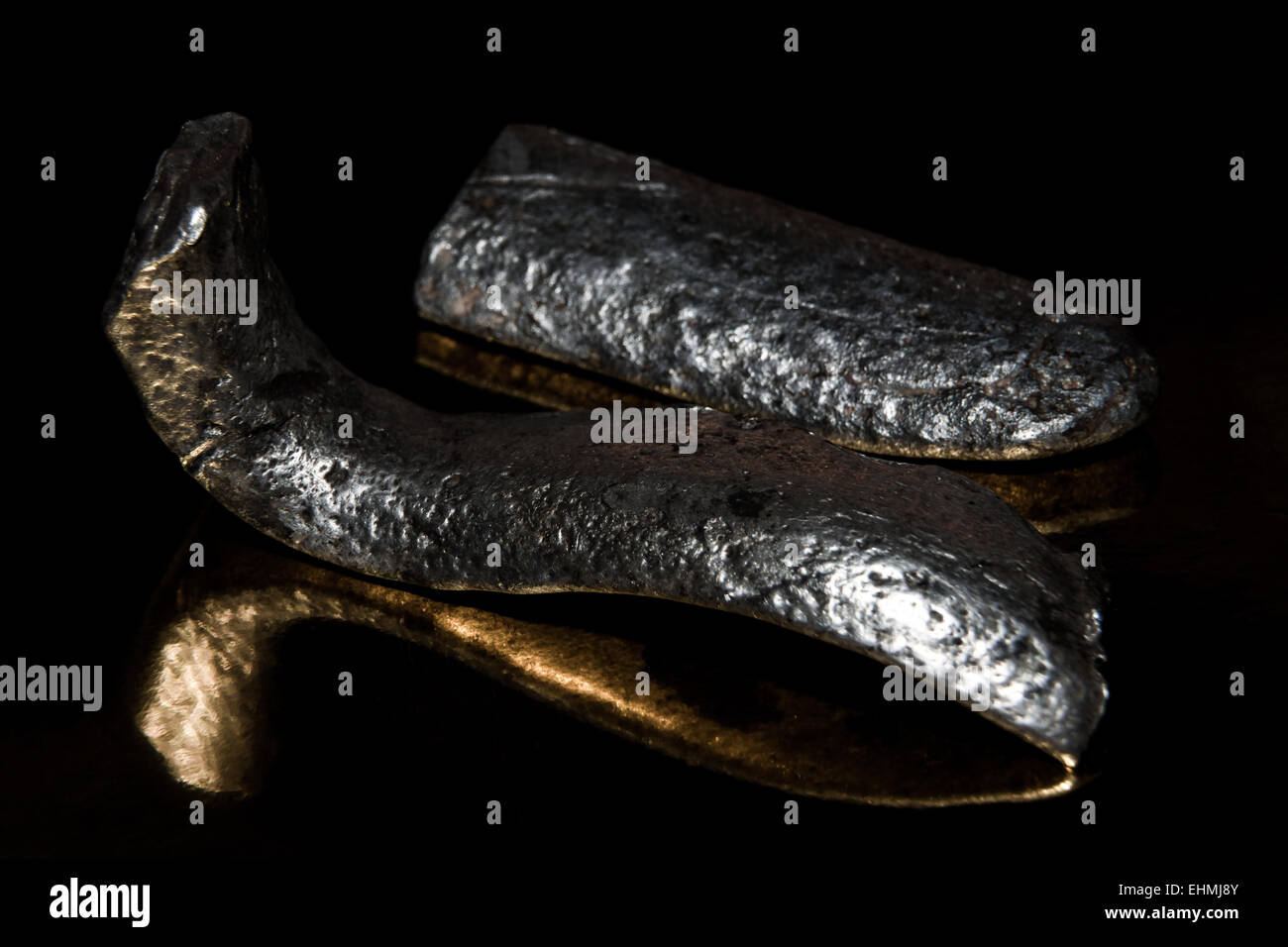 two ancient bars of silver lie on a golden background