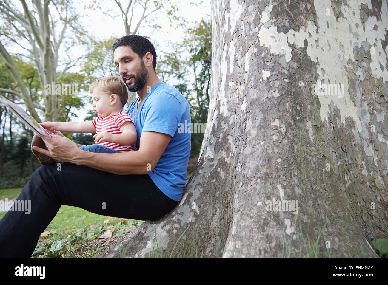 Caucasian father and baby son using digital tablet outdoors Stock Photo