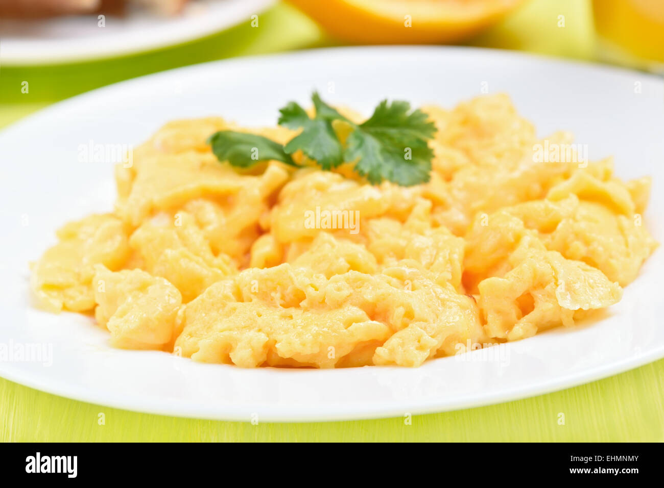 Scrambled eggs on white plate, close up view Stock Photo - Alamy