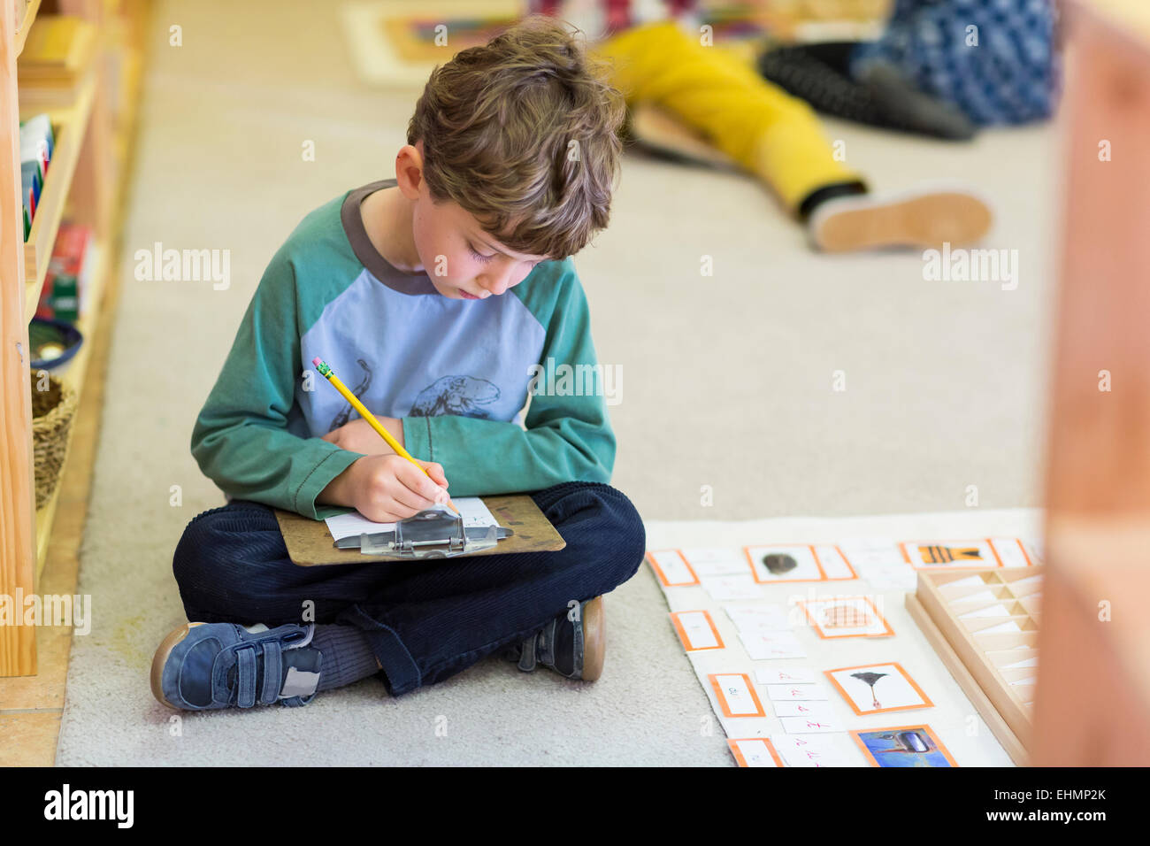 Boy writing in classroom Stock Photo