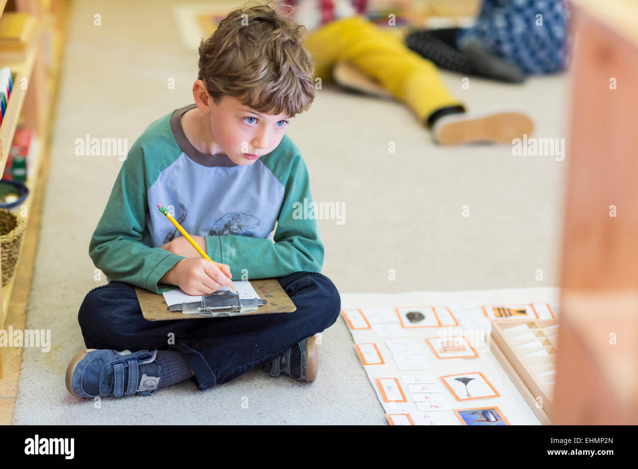 Boy writing in classroom Stock Photo