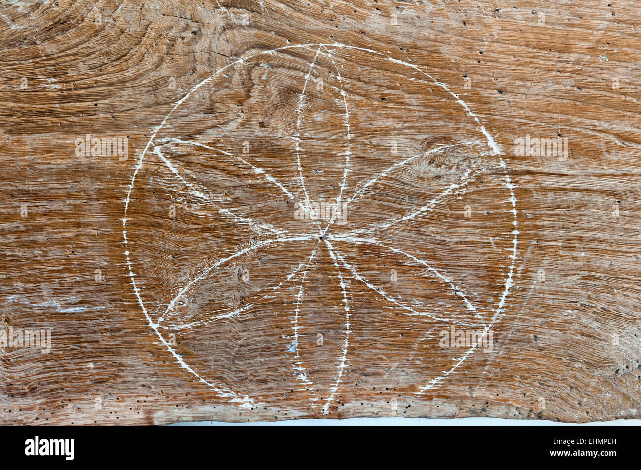 A witch mark (apotropaic mark) in a 16c Herefordshire house (UK). A protective sign in a daisy wheel shape carved into a wooden beam Stock Photo