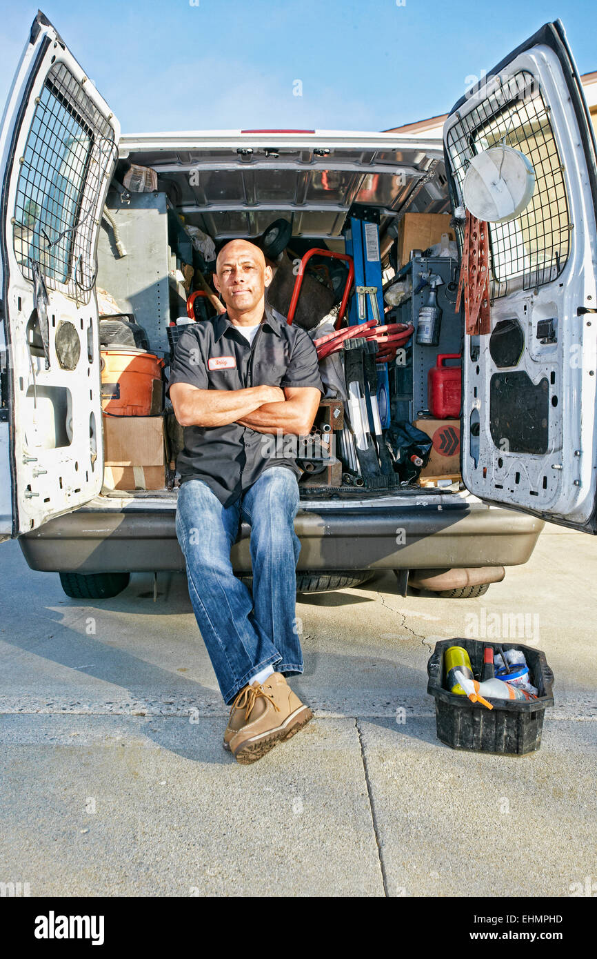Mixed race plumber sitting in van Stock Photo Alamy