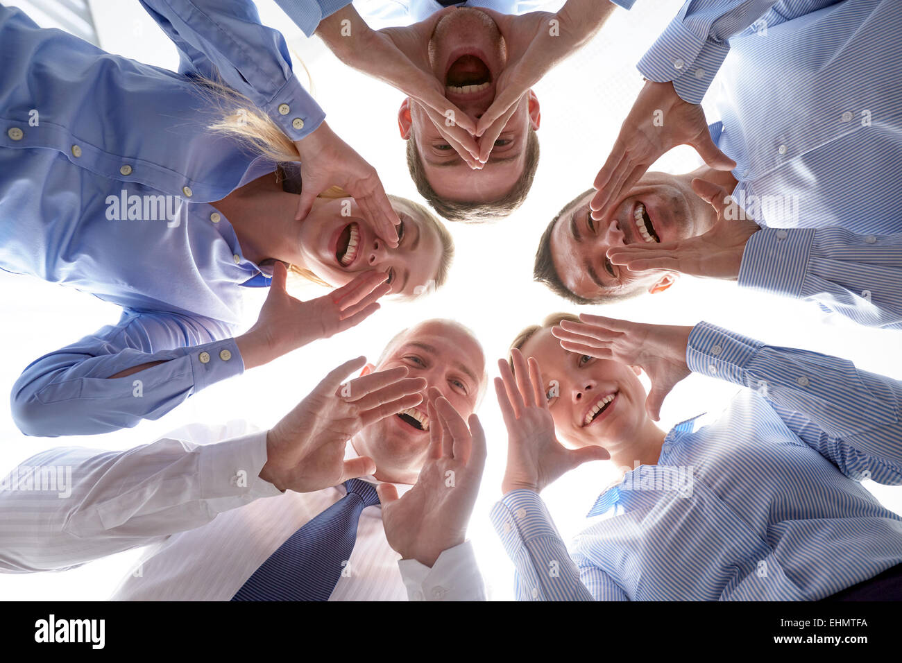 smiling group of businesspeople standing in circle Stock Photo