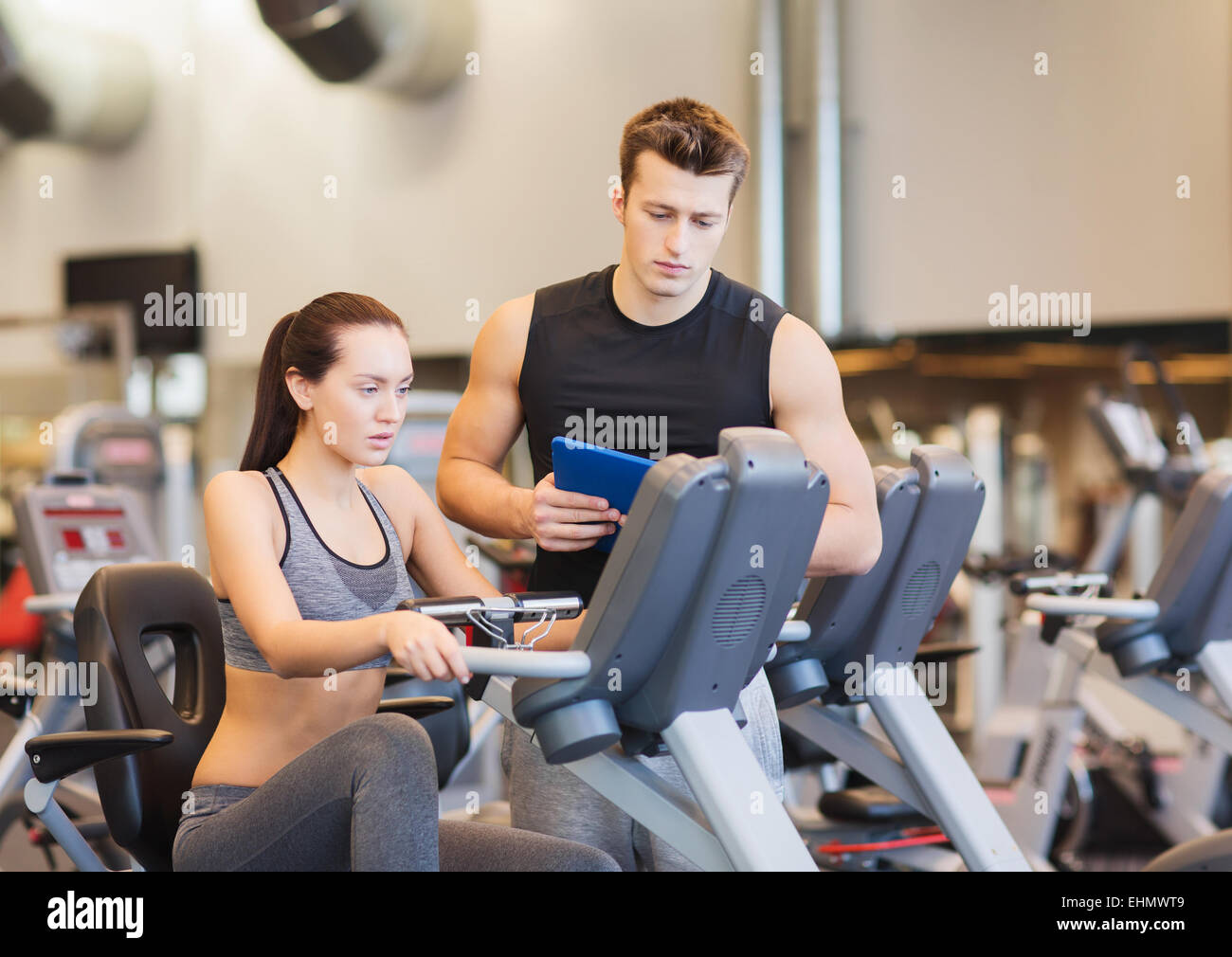 woman with trainer on exercise bike in gym Stock Photo - Alamy