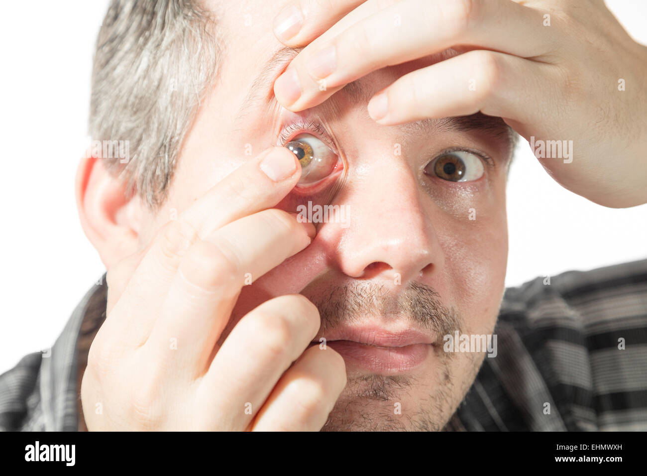 Picture of a man putting on a contact lens Stock Photo