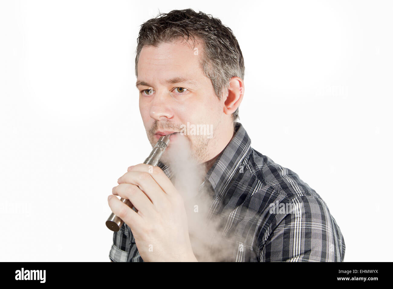 Picture of a man smoking on a e cigarette with smoke beeing exhaled Stock Photo