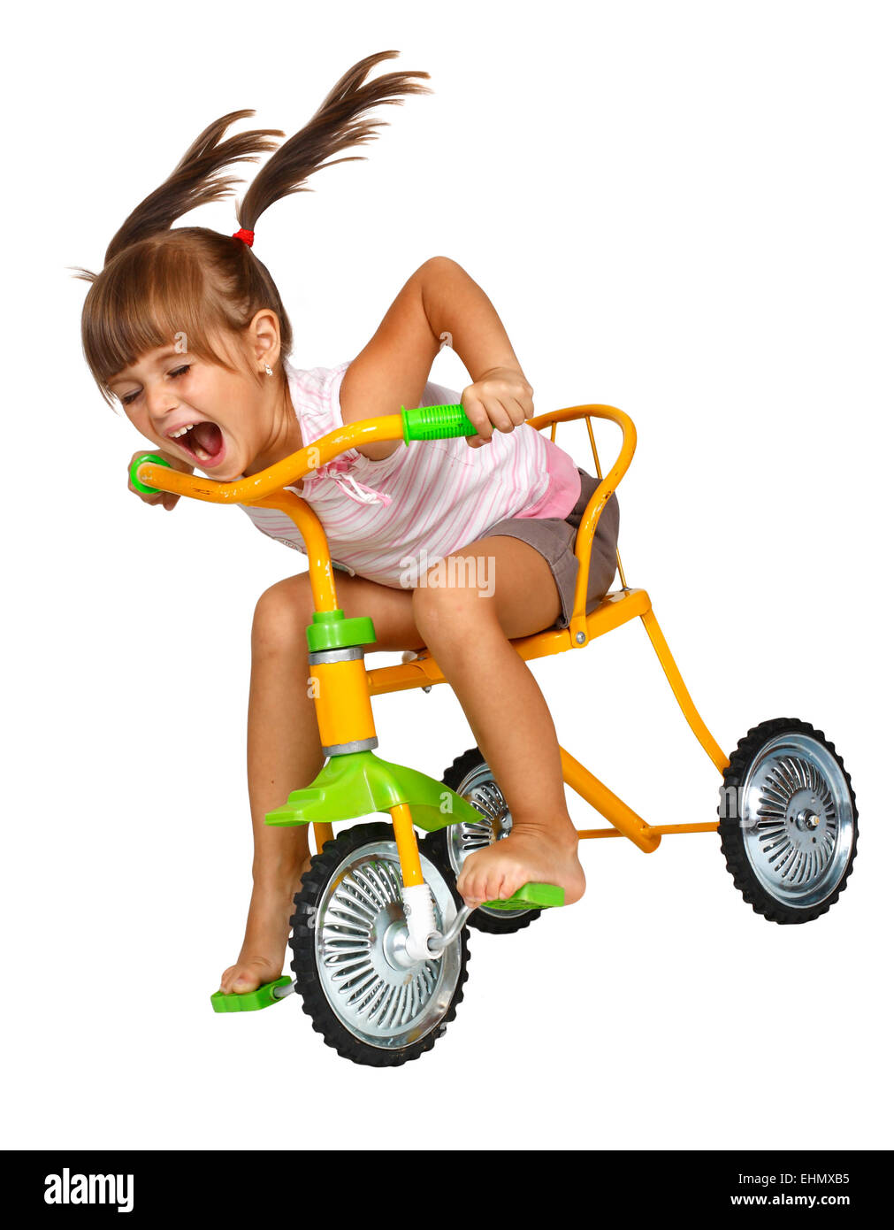 Child girl with long tails drive bicycle very fast Stock Photo