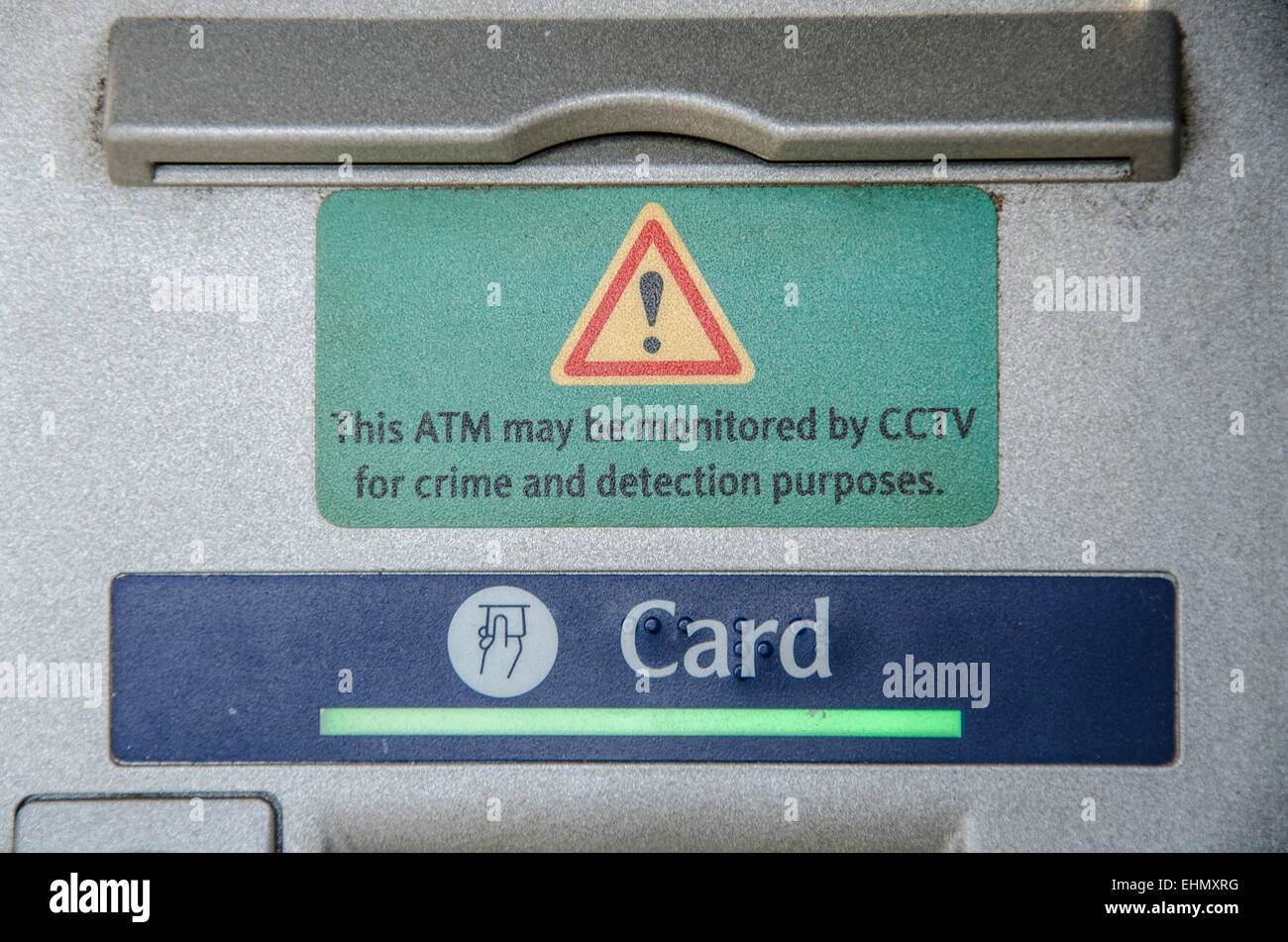 Security warning of CCTV monitoring for ATM cash machines, or 'hole in the wall' machine with security warning notice. Card slot Stock Photo