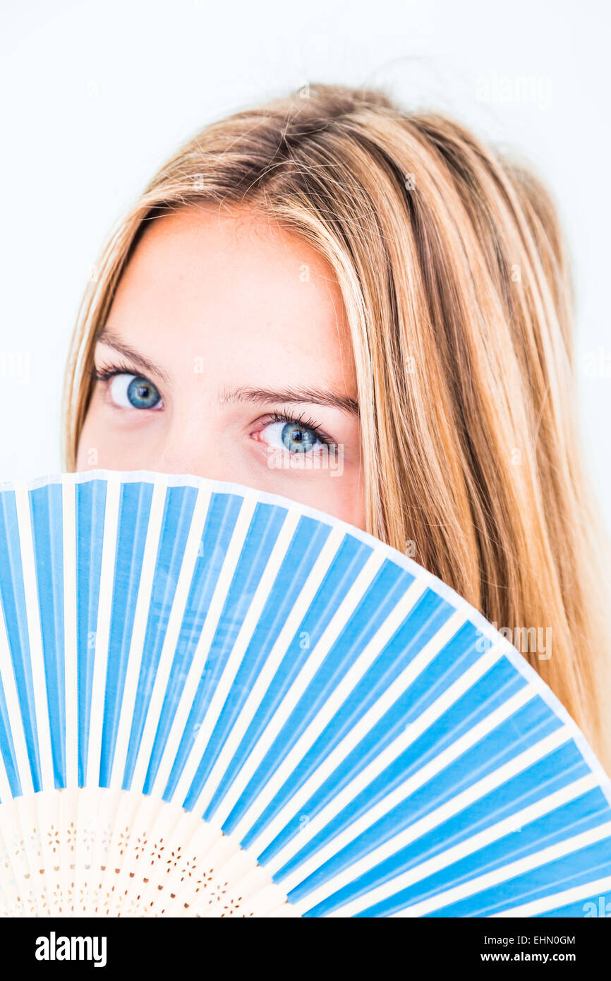 Woman cooling her face with a fan. Stock Photo