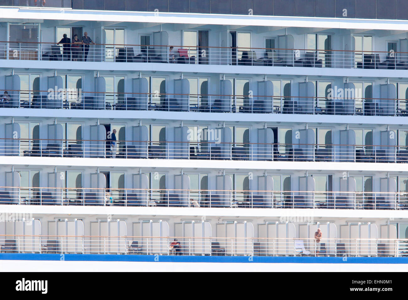 Cruise ship with passengers standing at balcony. Stock Photo