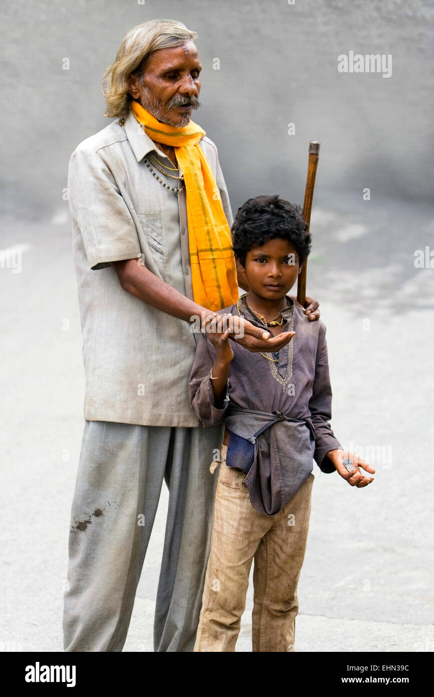 A blind man begging for money with the help of a young boy on September 11, 2008 in the streets of Udaipur, India Stock Photo
