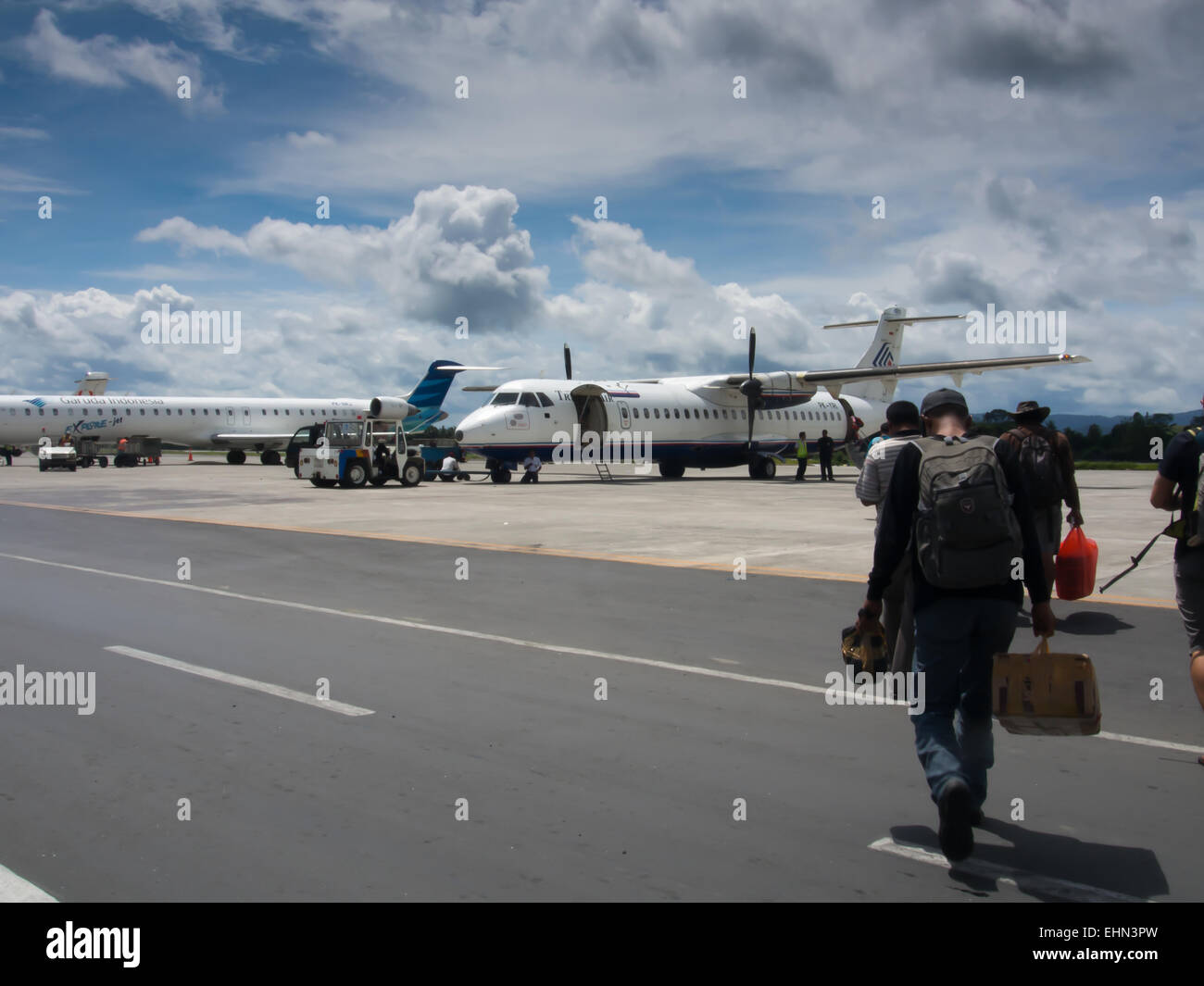 Jayapura, Indonesia - January 12, 2015: Passengers boarding local airlines plane… Stock Photo
