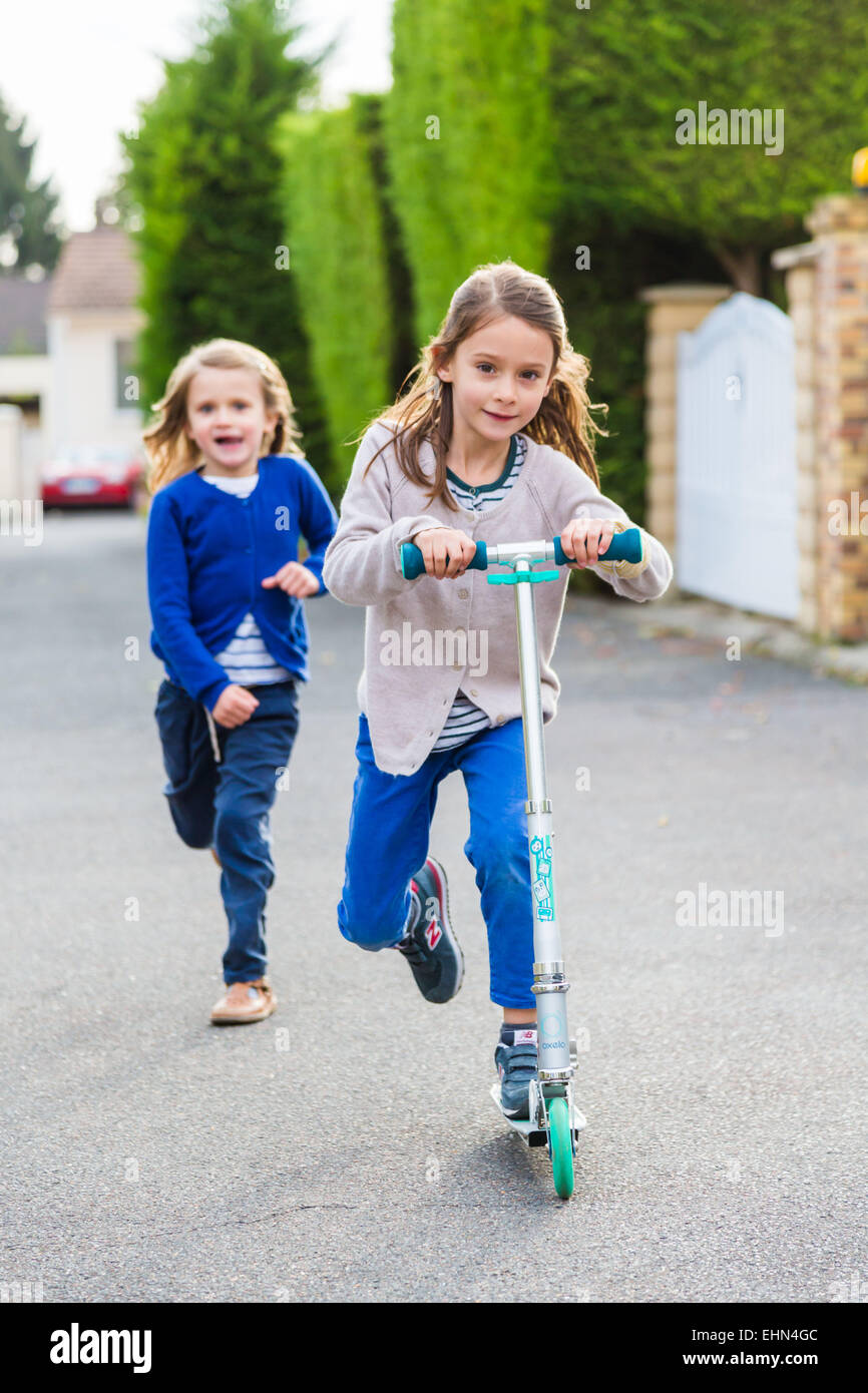 Children on scooters outdoors. Stock Photo