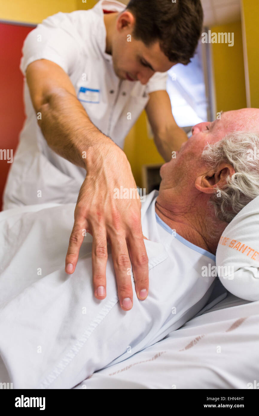 Man after a stroke doing physiotherapy exercises with a physiotherapist. Bordeaux hospital, France. Stock Photo