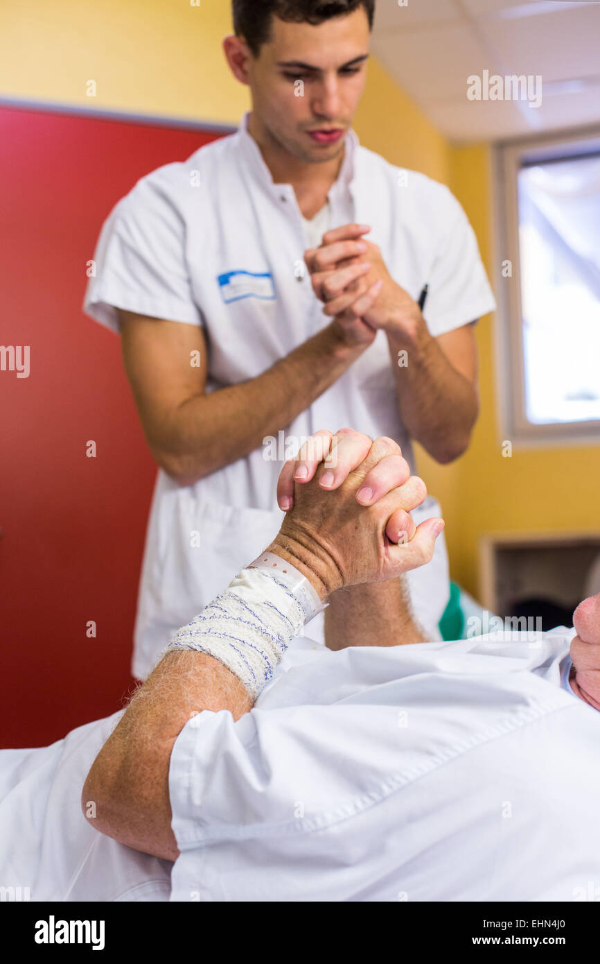 Man after a stroke doing physiotherapy exercises with a physiotherapist. Bordeaux hospital, France. Stock Photo
