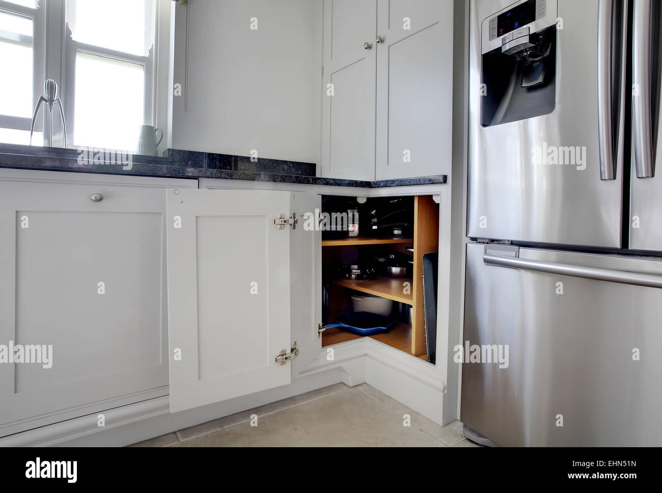 A Modern White Kitchen In A Home In The Uk With The Corner Cupboard Door Open Stock Photo Alamy