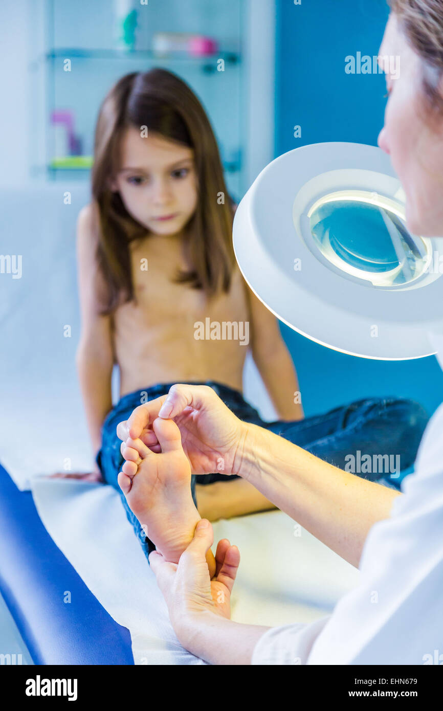 Doctor examining girl's foot. Stock Photo