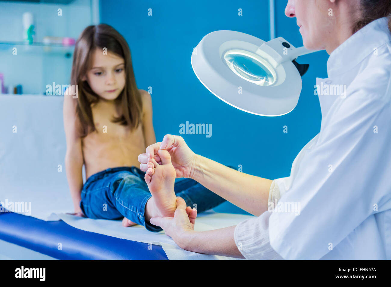 Doctor examining girl's foot. Stock Photo