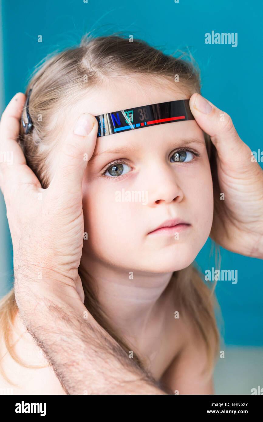 Measuring body temperature, using a strip thermometer. Stock Photo