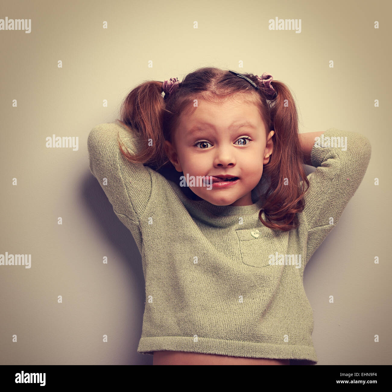 Funny girl showing tongue and making surprising fun face. Vintage portrait Stock Photo
