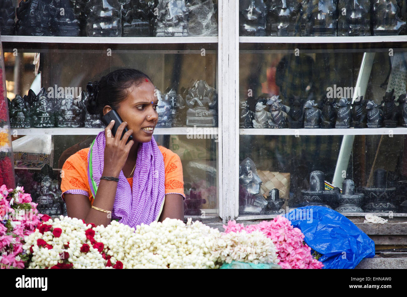 A female shopkeeper selling pooja flowers for offering at Kapaleeshwarar temple,Mylapore,Chennai,Tamilnadu,India Stock Photo