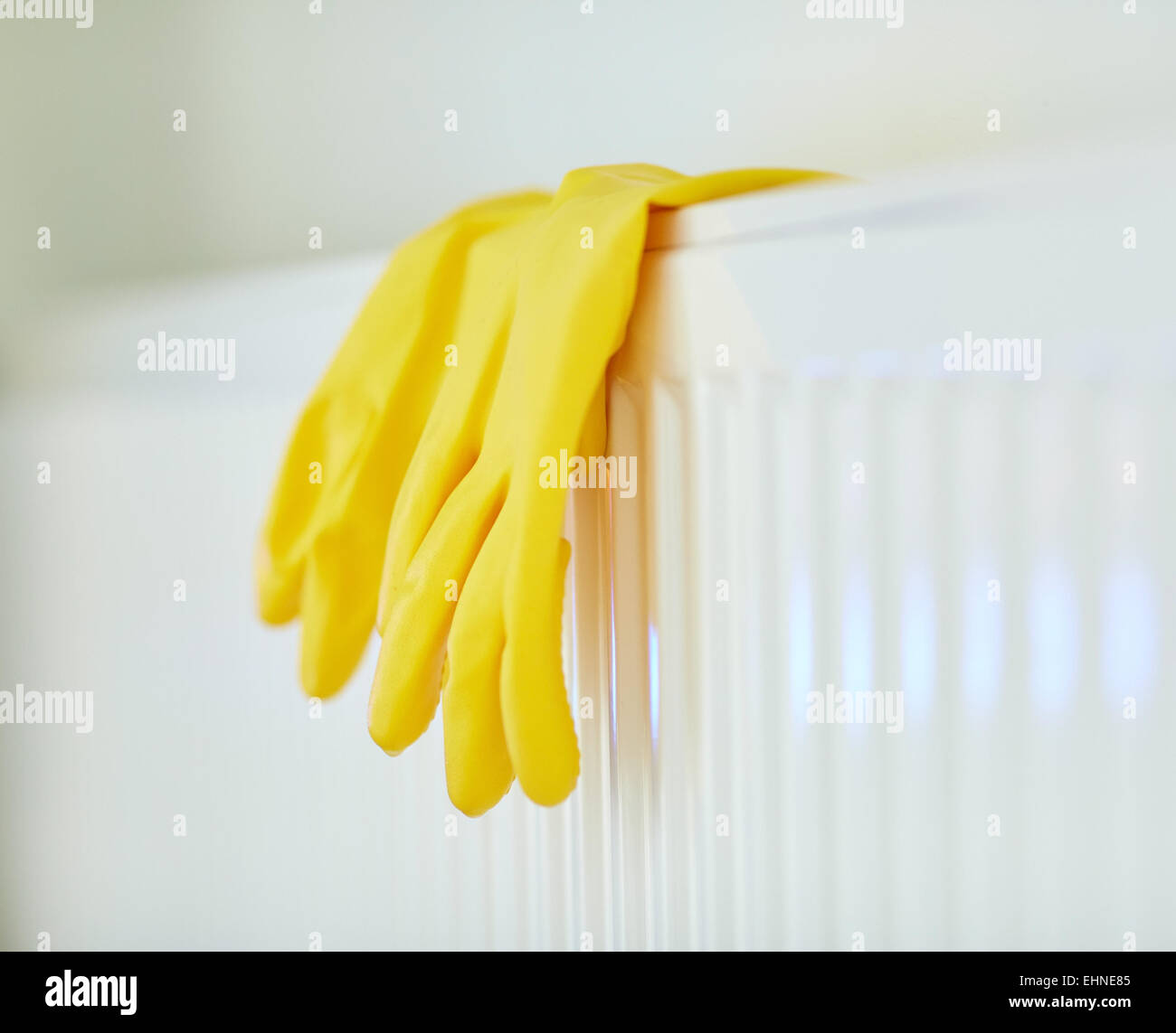 close up of rubber gloves hanging on heater Stock Photo