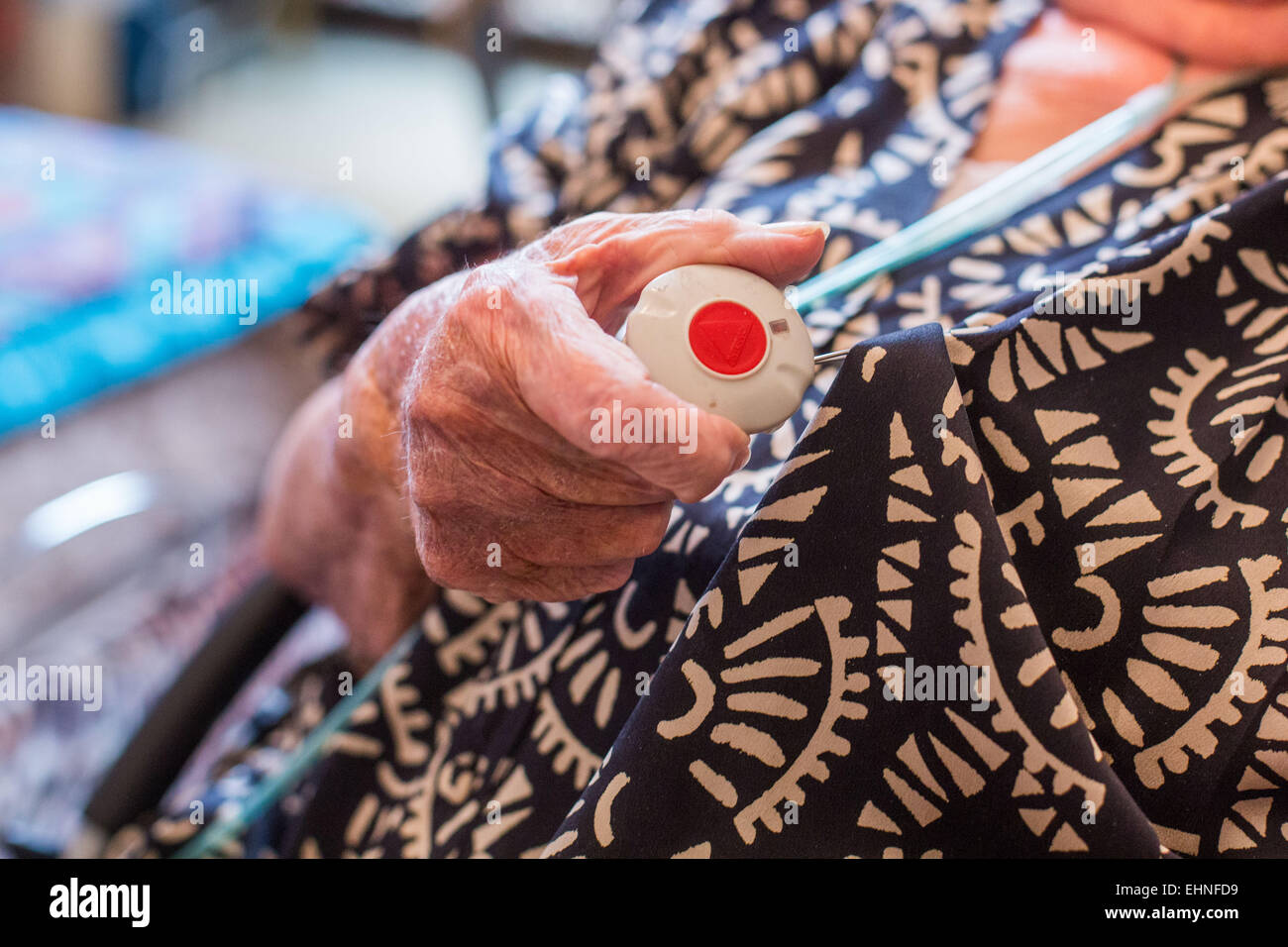 Emergency call button. Elderly woman wearing a remote assistance unit at home. Stock Photo