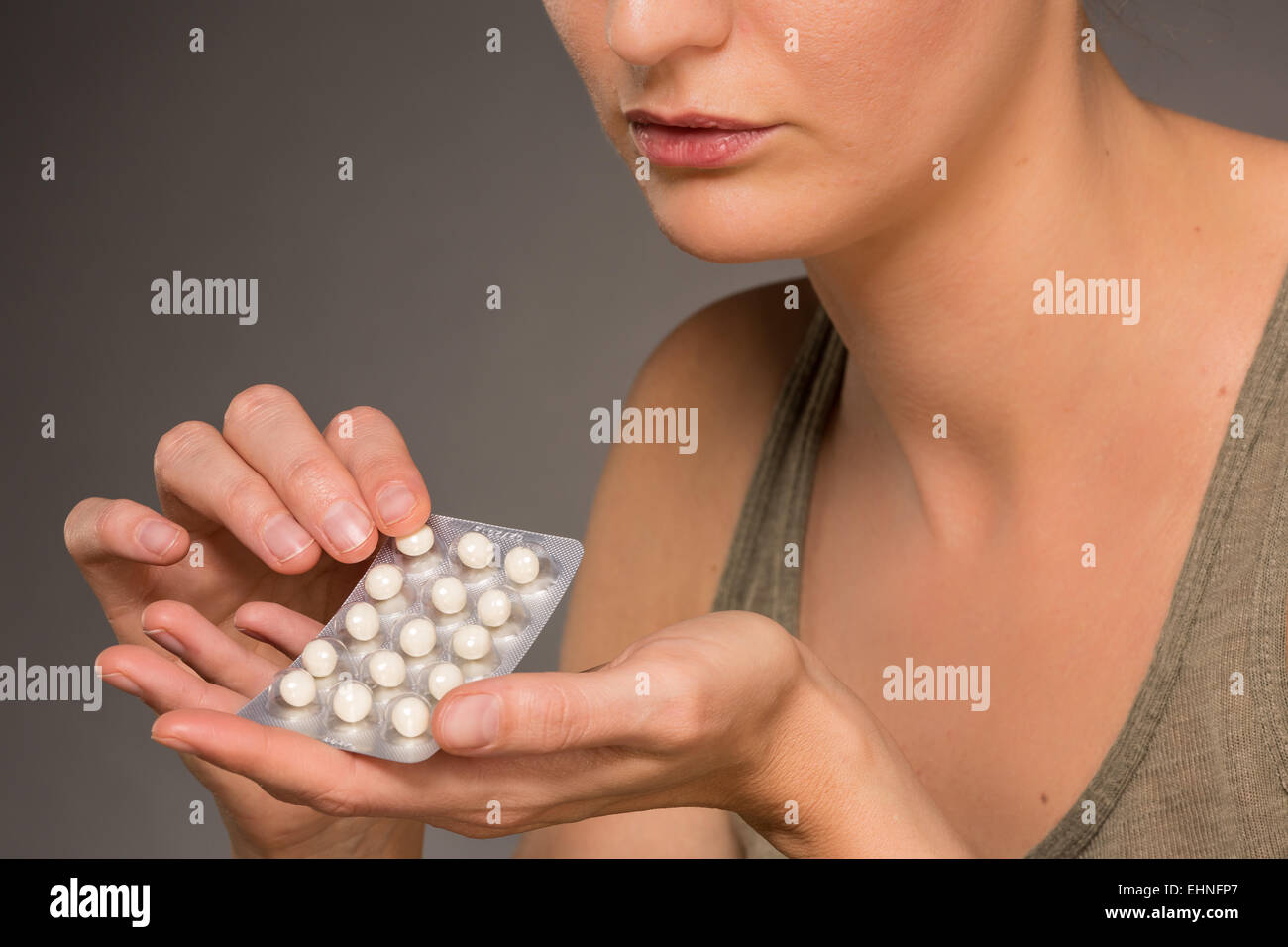 Woman taking an hormone replacement therapy pills. Stock Photo