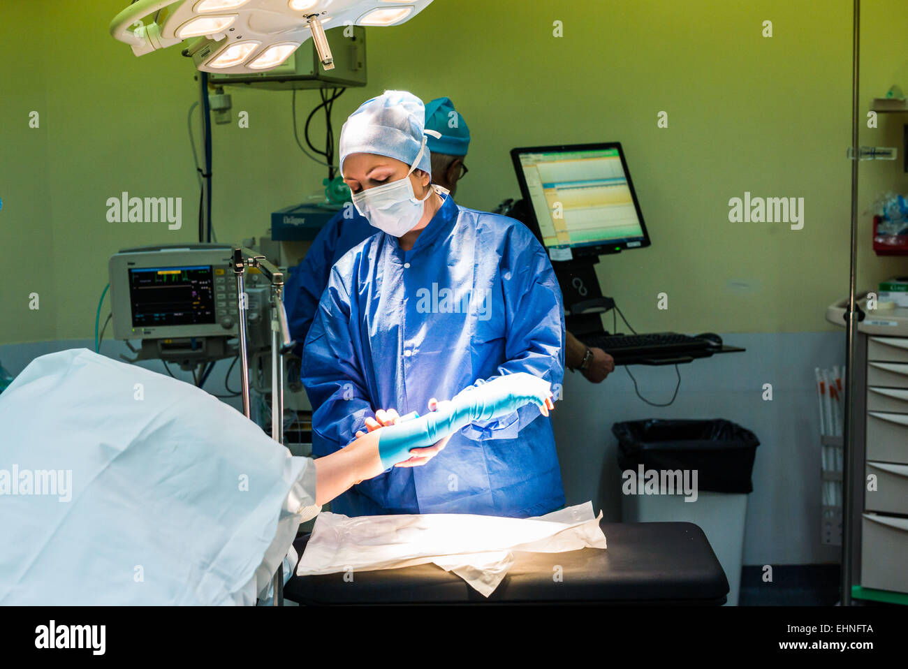 Nurse placing a compression band on a patient before orthopedic surgery, Jouvenet clinic, Paris, France. Stock Photo