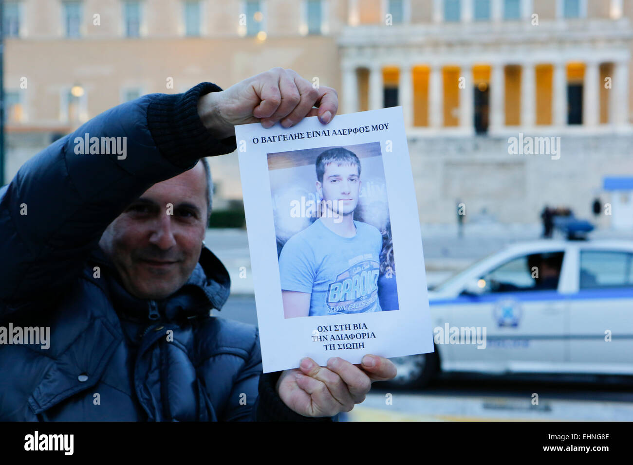 Athens, Greece. 16th March 2015. A man holds up a poster with a picture of Vangelis Giakoumakis that reads 'Vangelis is my σιστερ - No to violence, indifference, silence'. A vigil was held for dead student Vangelis Giakoumakis in Syntagma Square in Athens. Giakoumakis, a alleged bullying victim was found dead from alleged suicide near the Greek city of Ioannina, after he vanished around a month ago. Credit:  Michael Debets/Alamy Live News Stock Photo