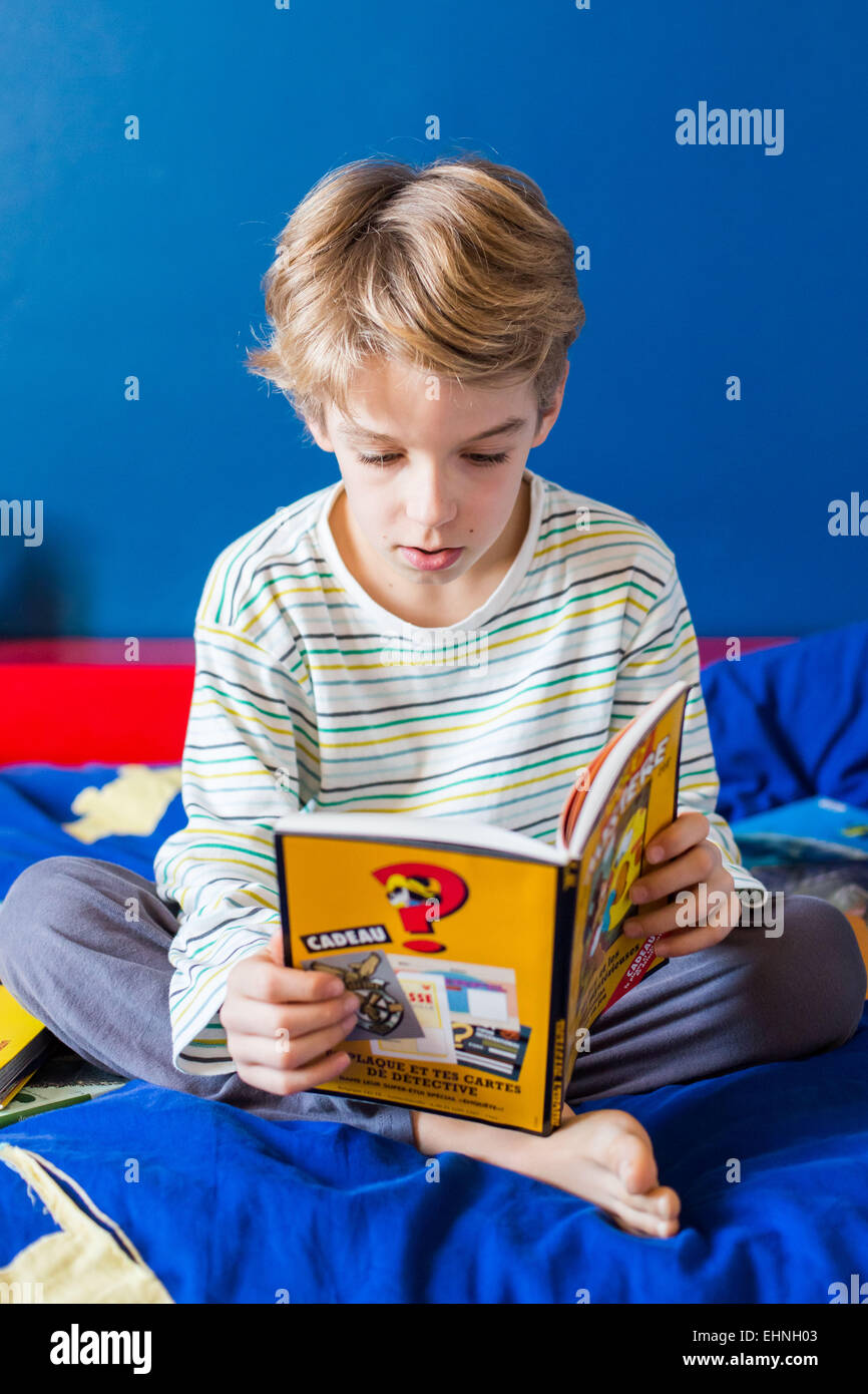 8 year old boy reading . Stock Photo