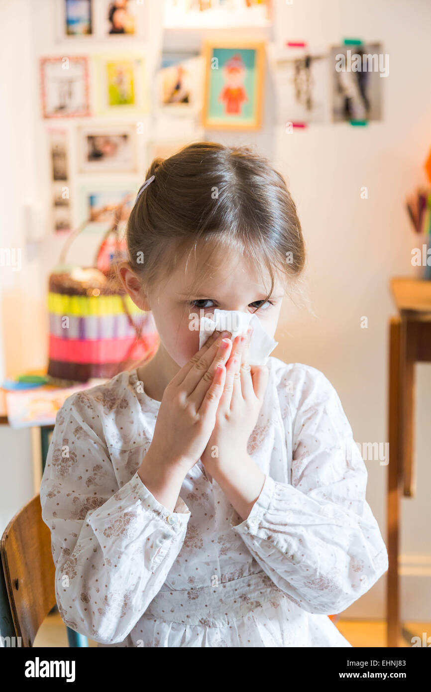 5 year-old girl blowing nose. Stock Photo