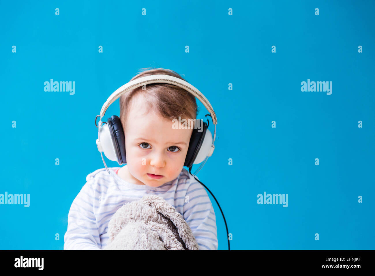 18 month-old baby boy listening music. Stock Photo