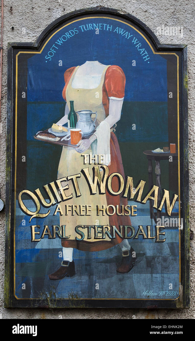 Amusing inn sign of The Quiet Woman in Earl Sterndale in the Derbyshire White Peak showing a headless woman with food and beer Stock Photo