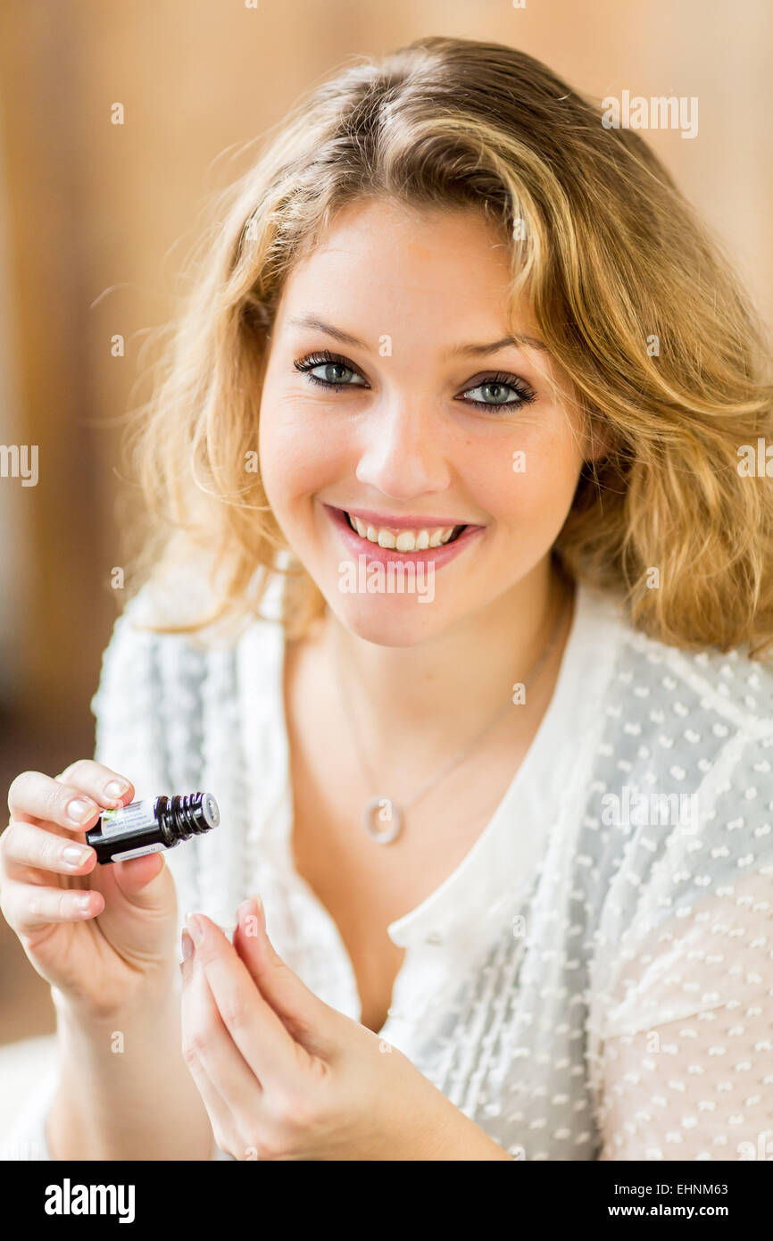 Woman applying essential oil on a neutral pill. Stock Photo