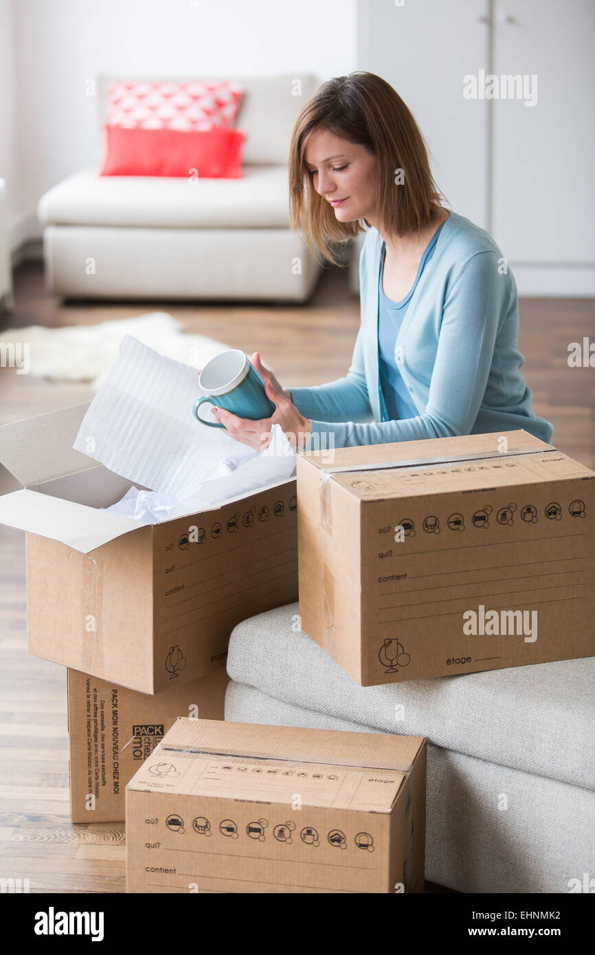 Woman carrying moving boxes in her new home. Stock Photo