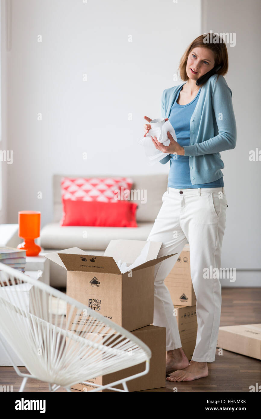 Woman carrying moving boxes in her new home. Stock Photo