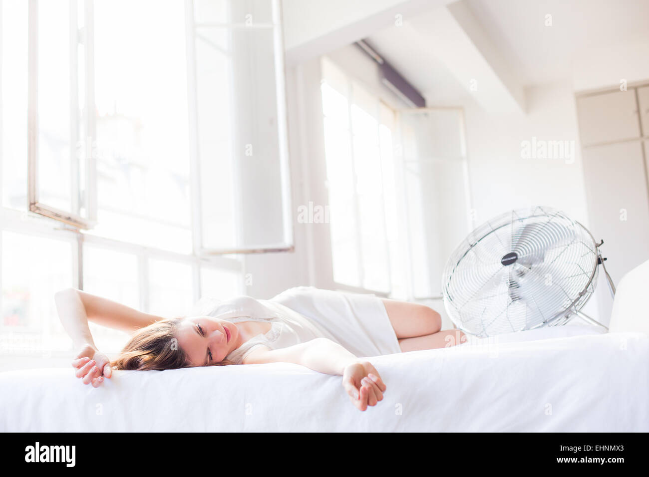 Woman in front of electric fan. Stock Photo