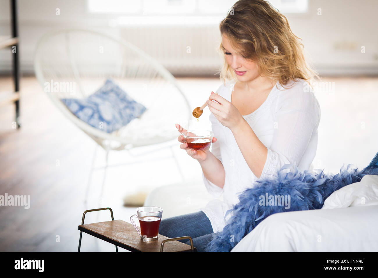 Woman adding of honey in an infusion. Stock Photo