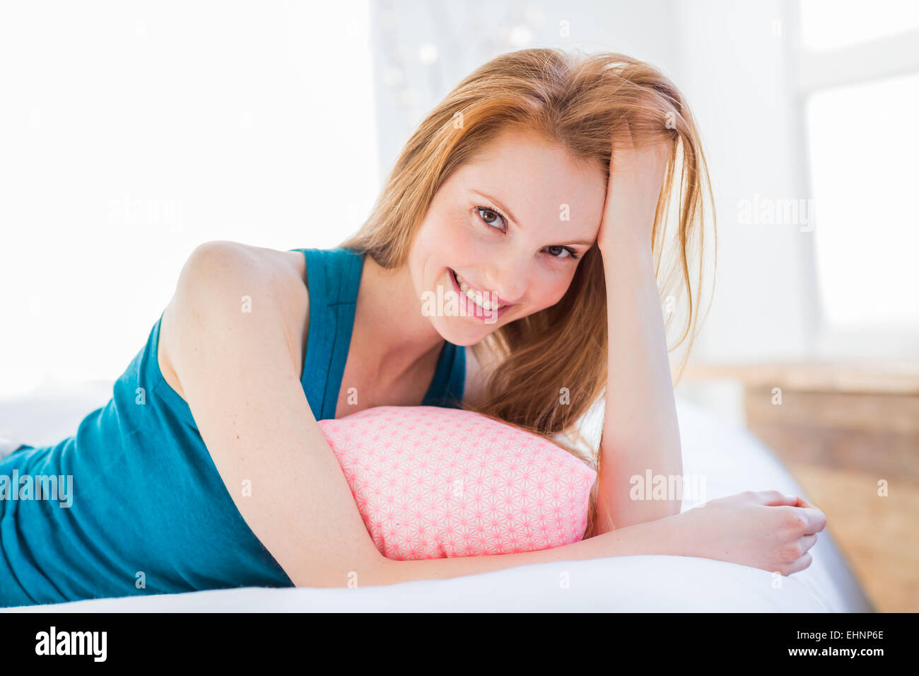 Young woman lying in bed. Stock Photo