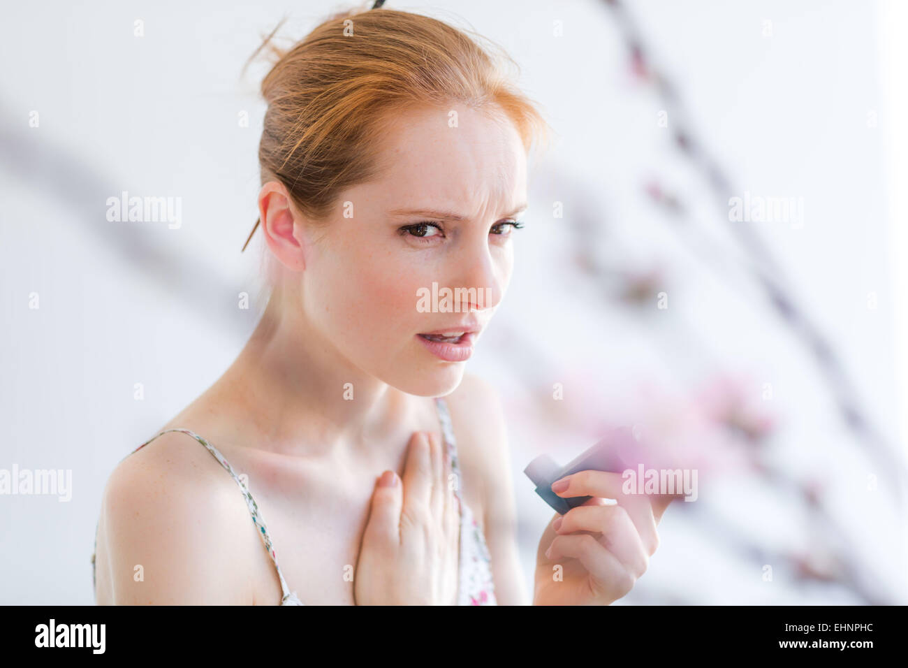 Woman using an aerosol inhaler that contains bronchodilator for the