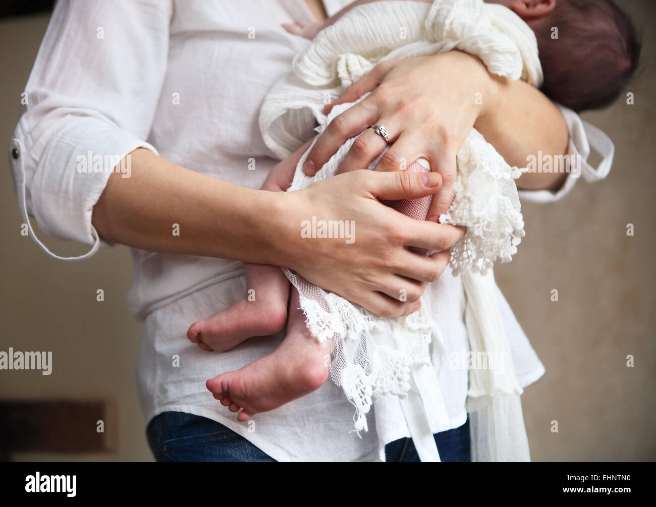 Baby boy falling asleep in the arms of her mother Stock Photo - Alamy