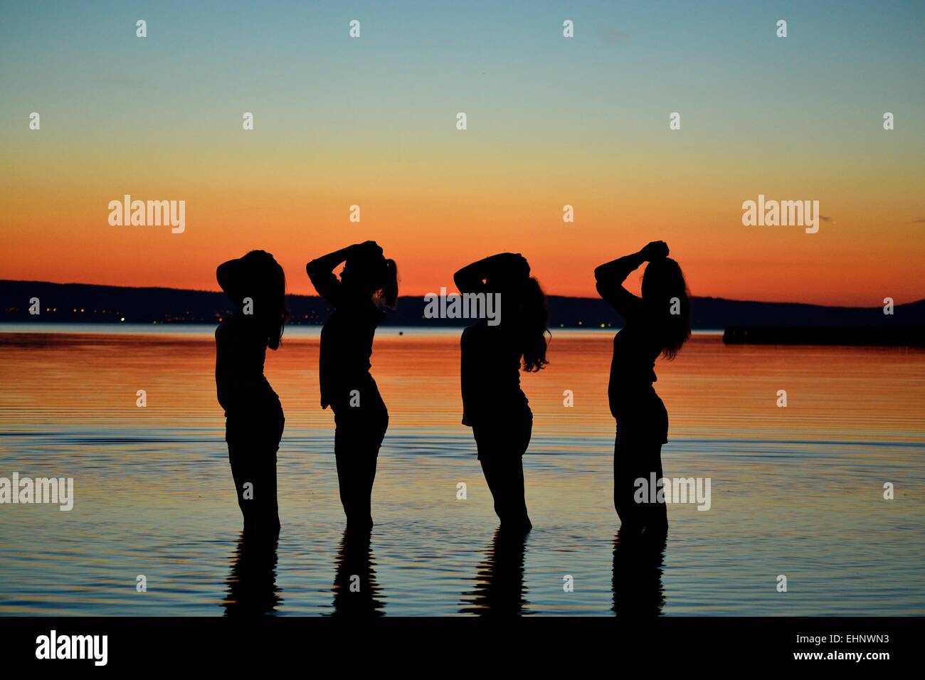 Four teenage silhouettes at sunset Stock Photo