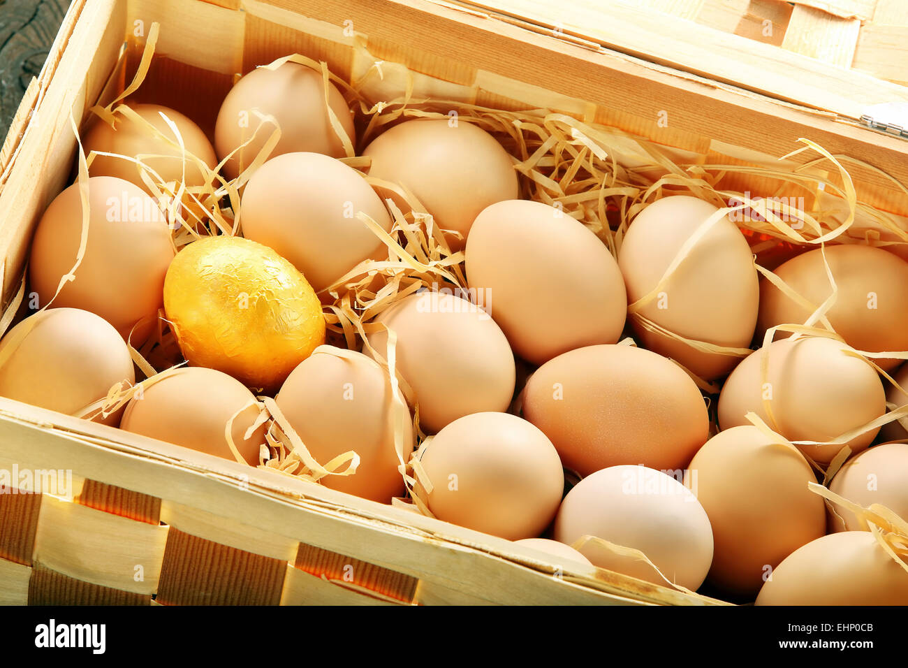Gold egg in a basket full of eggs Stock Photo Alamy