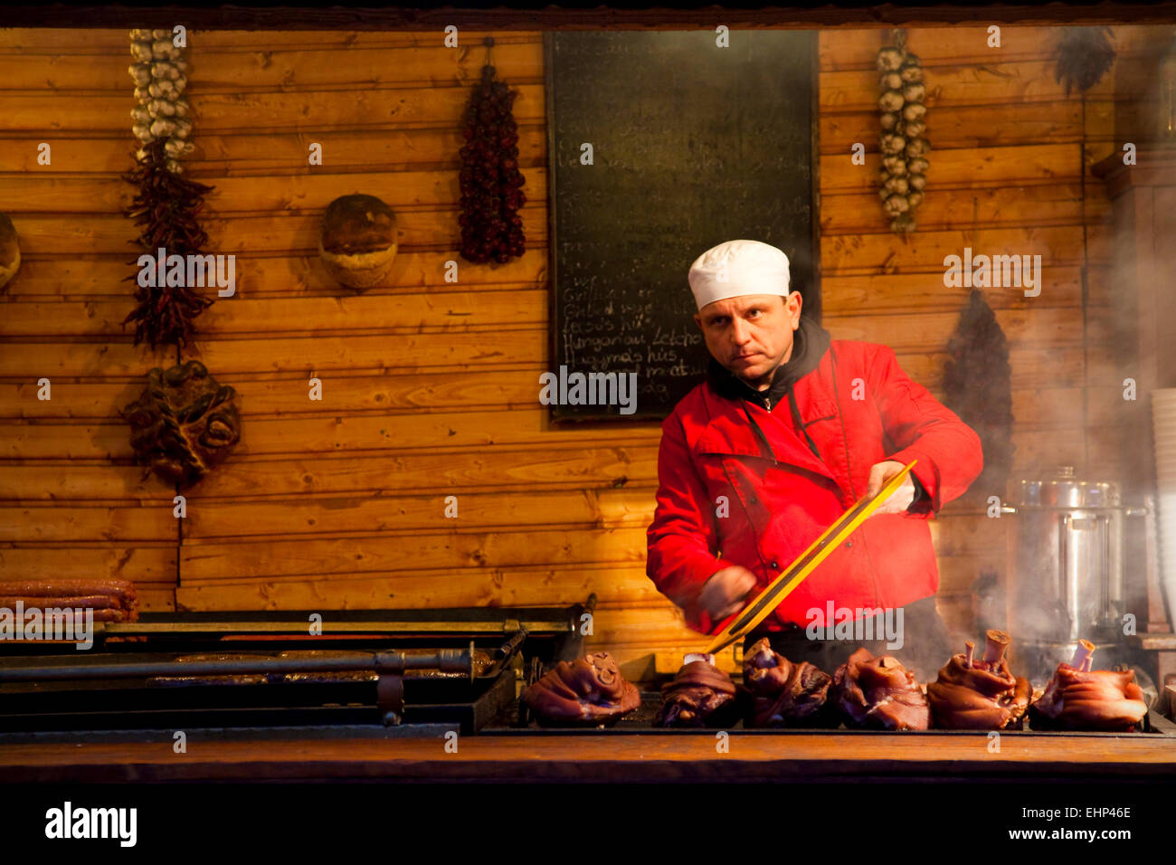 A chef cooks meat on a grill at a Christmas Market in Budapest, Hungary Stock Photo