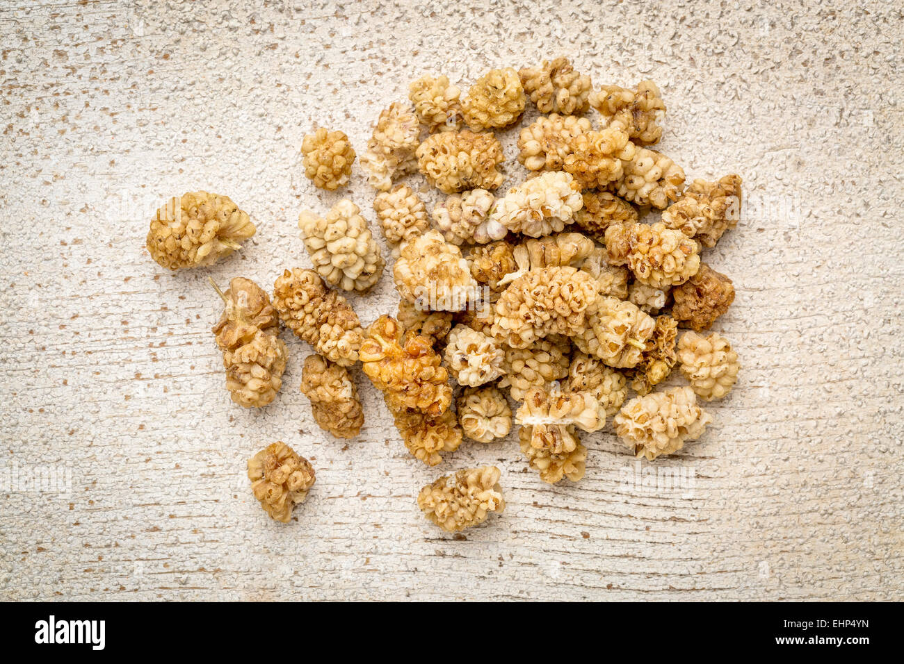 a pile of dried white mulberry fruit against rustic barn wood Stock Photo