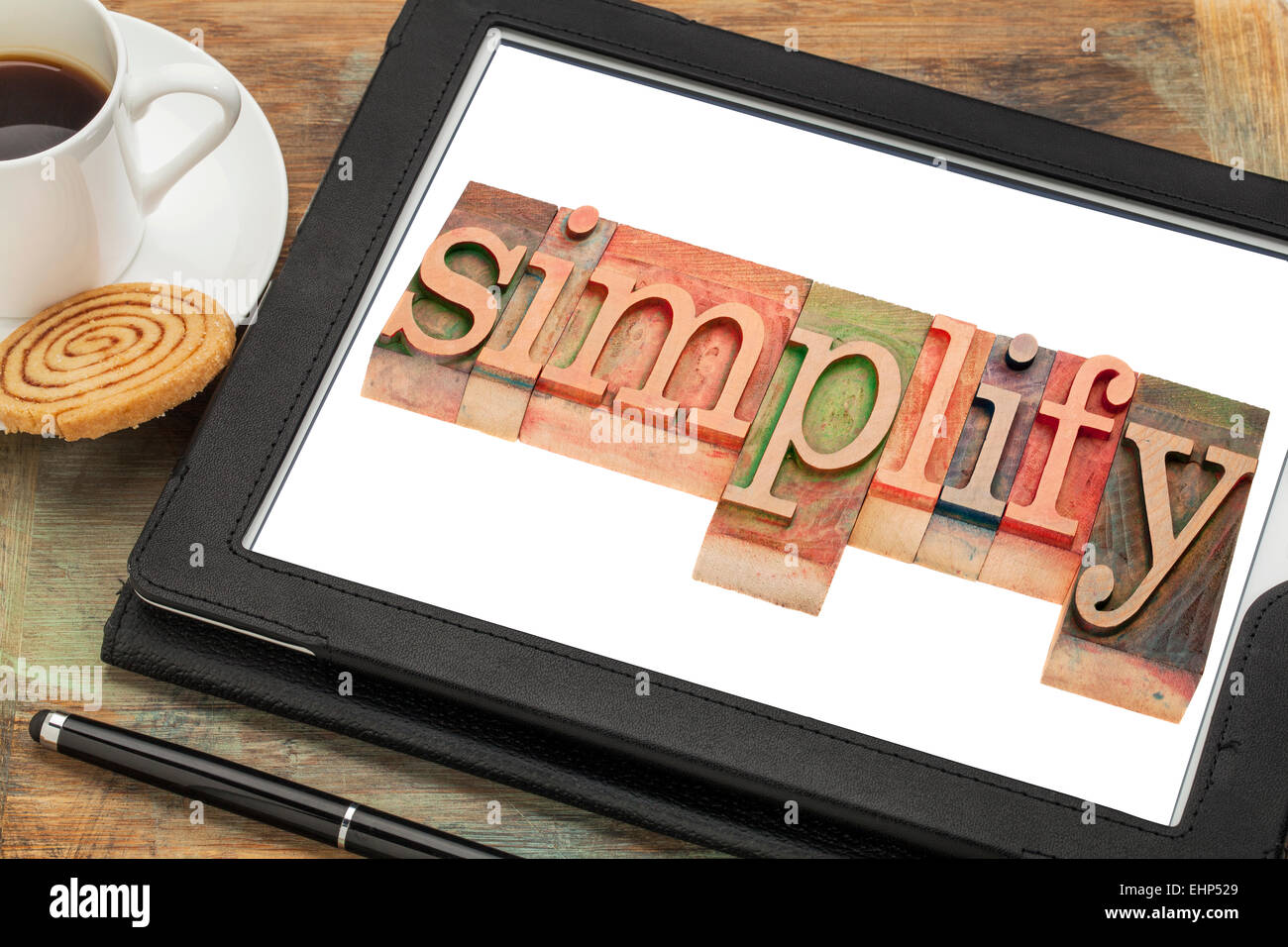 simplify word typography - text in letterpress wood type on a digital tablet with a cup of coffee Stock Photo