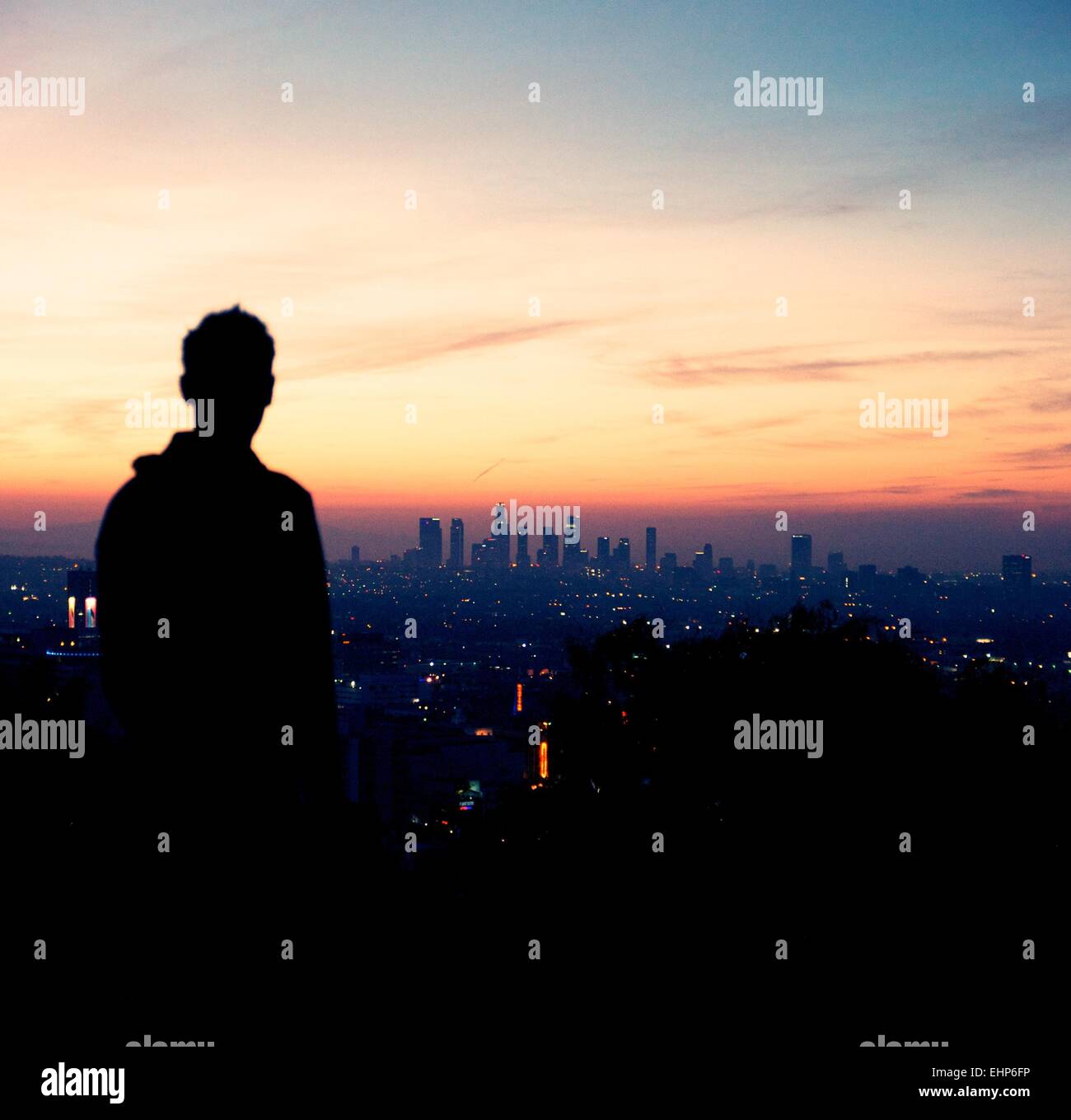 Man looks at sunrise over Los Angeles skyline. Stock Photo