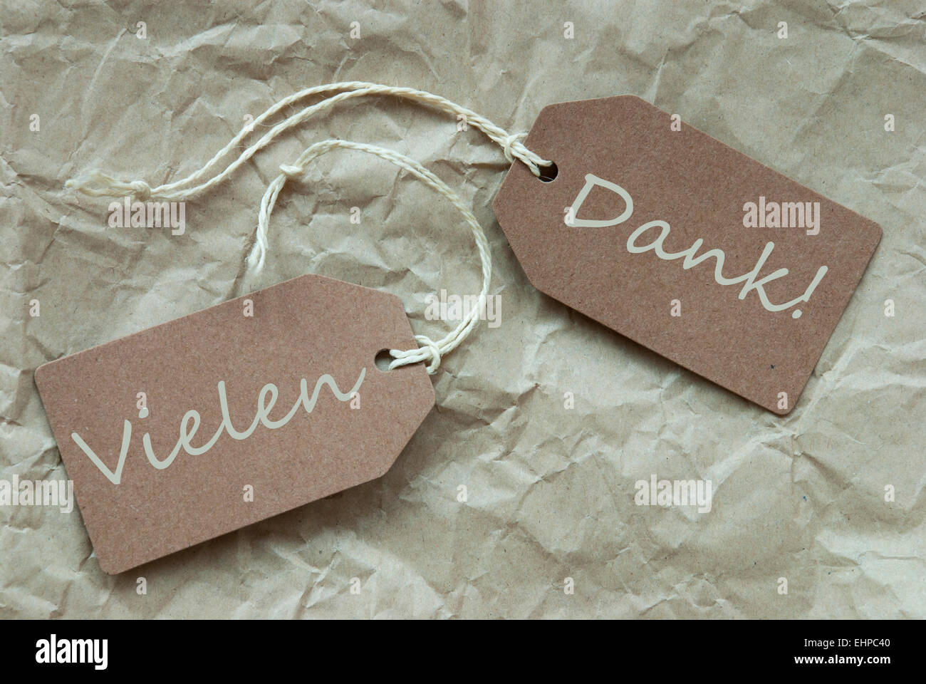 Two Beige Labels Or Tags With White Ribbon On Crumpled Paper Background With German Text Vielen Dank Means Thank You Vintage Or Stock Photo